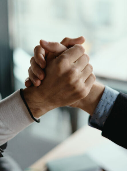 Close up two businessmen shaking hands. Positive management team celebrating victory, successful stock deal, sales growth, won good contract, business achievement and teamwork concept